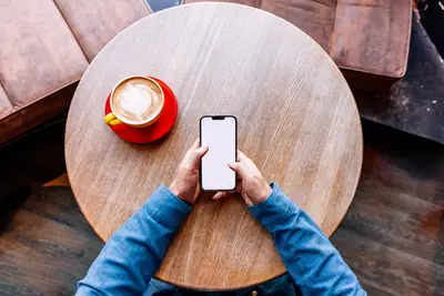 Smartphone resting on a cafe table where a motion alarm guards it